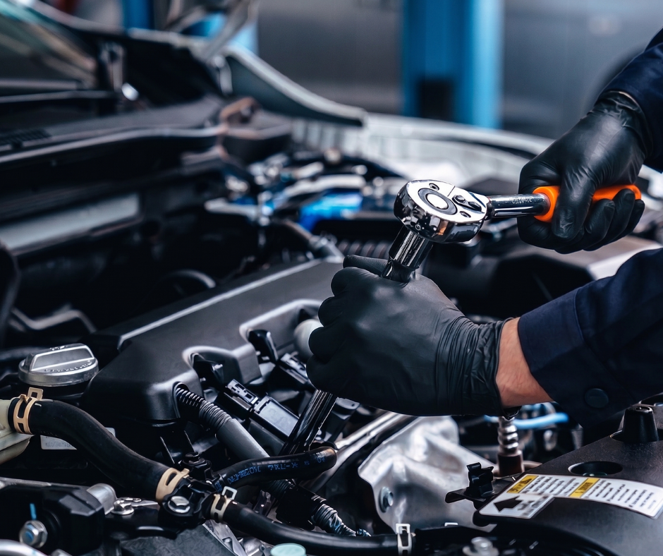 A Mechanic Using A Ratchet Tool To Work On A Car Engine
