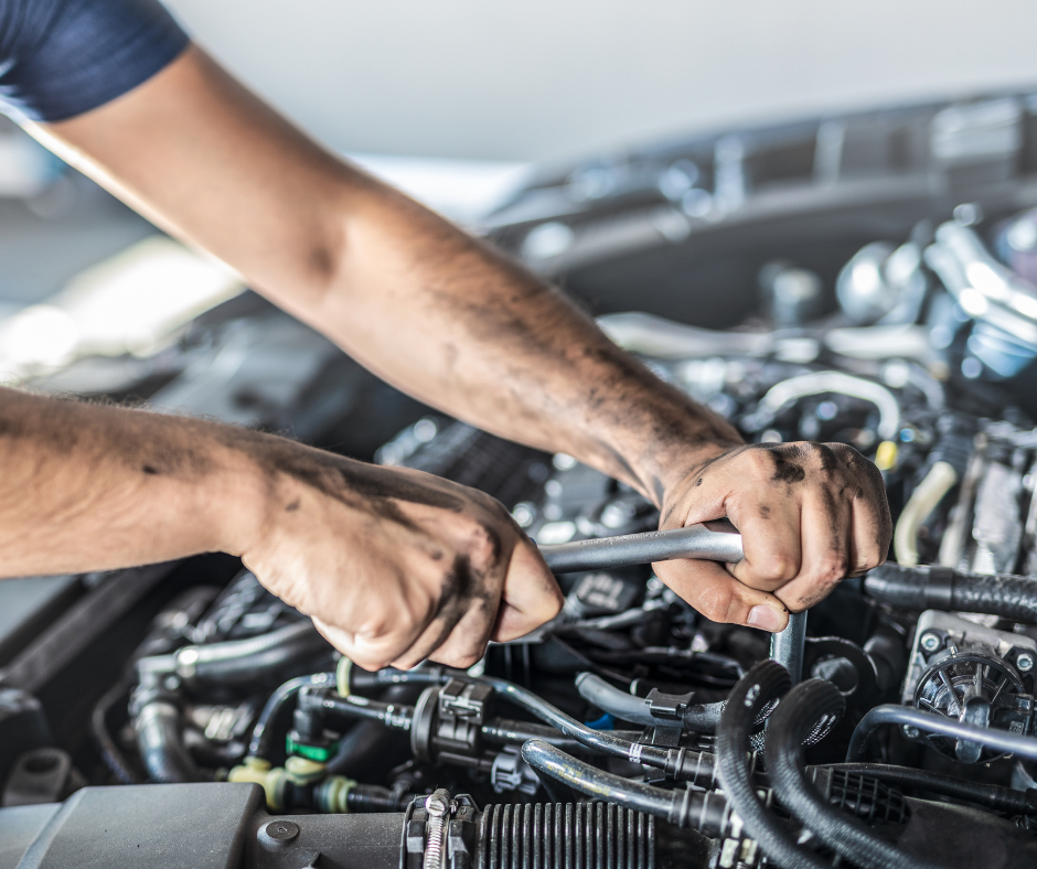 Auto Mechanic Using A Wrench To Work On A Car Engine