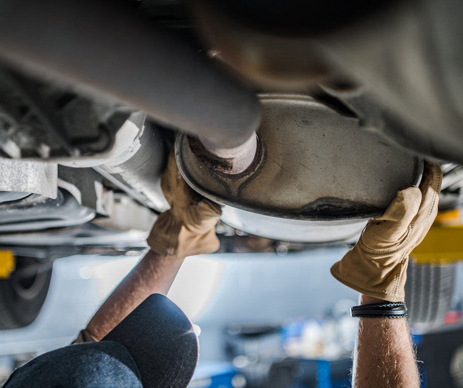 Mechanic Repairing A Vehicle's Exhaust Muffler